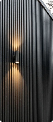 Black vertical metal siding with an exterior wall light